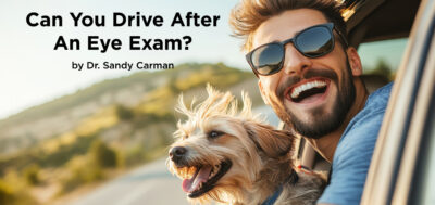 Man with glasses and dog driving in car smiling.